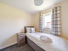 A bedroom with a single bed and nightstand at Sage Lodge Near Brigg