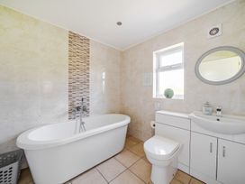 A bathroom with a bathtub, sink, and toilet at Sage Lodge Near Brigg