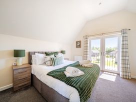 A bedroom with a bed and balcony doors at Sage Lodge Near Brigg