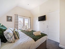 A bedroom with a bed and television at Sage Lodge near Brigg