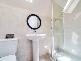 A bathroom with a toilet, sink, mirror and shower at Sage Lodge near Brigg