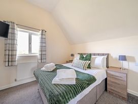 A bedroom with a bed and bedside table at Sage Lodge near Brigg