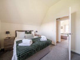 A bedroom with a bed and nightstand at Sage Lodge near Brigg