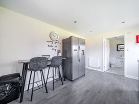 A kitchen with bar stools and refrigerator at Raven Lodge Near Brigg