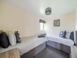 A bedroom with two beds and a window at Raven Lodge near Brigg