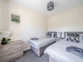 A bedroom with two beds and a dresser at Raven Lodge Near Brigg