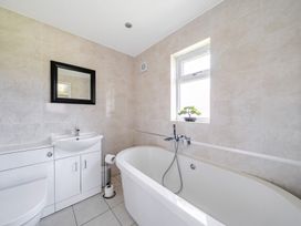 A bathroom with a bathtub, sink, and toilet at Raven Lodge near Brigg