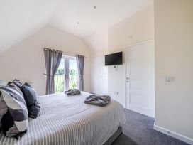 A bedroom with a bed and TV at Raven Lodge Near Brigg