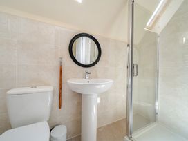 A bathroom with a toilet, sink, and shower at Raven Lodge near Brigg