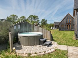 An outdoor area with a hot tub and house at Raven Lodge near Brigg