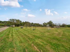 An outdoor area with swings and playground equipment at Raven Lodge near Brigg