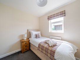 A bedroom with a single bed and bedside table at Paddington Lodge Near Brigg