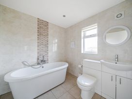 A bathroom with a bath tub and sink at Paddington Lodge Near Brigg
