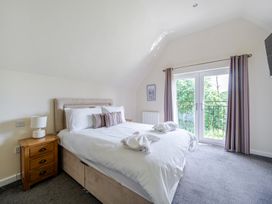 A bedroom with a bed and balcony doors at Paddington Lodge Near Brigg