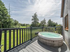 An outdoor area with a hot tub on a deck at Paddington Lodge near Brigg