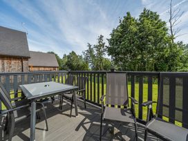 A deck with chairs and a table at Paddington Lodge Near Brigg