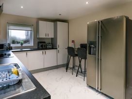 A kitchen with a refrigerator and counter at Charcoal Lodge in Brigg