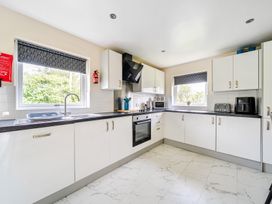 A kitchen with white cabinets and appliances at Charcoal Lodge in Brigg