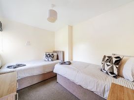 A bedroom with two beds and a bedside table at Charcoal Lodge in Brigg