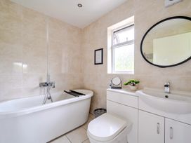A bathroom with a bathtub, toilet, and sink at Charcoal Lodge Brigg