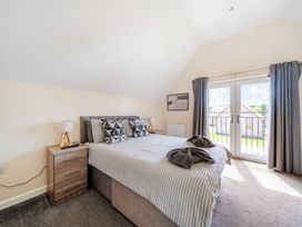 A bedroom with a bed and nightstand at Charcoal Lodge in Brigg