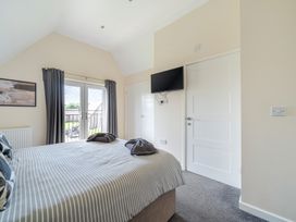 A bedroom with a bed and a television at Charcoal Lodge in Brigg