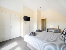 A bedroom with a bed and television at Charcoal Lodge in Brigg