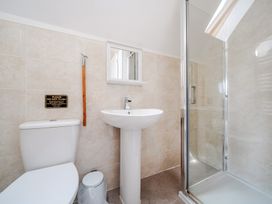 A bathroom with a toilet, sink, and shower at Charcoal Lodge in Brigg