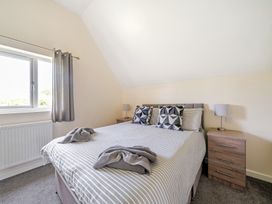 A bedroom with a bed and bedside tables at Charcoal Lodge in Brigg