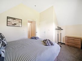 A bedroom with a bed and clothes rack at Charcoal Lodge in Brigg