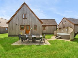 An outdoor area with wooden cabins and a hot tub at Charcoal Lodge Brigg