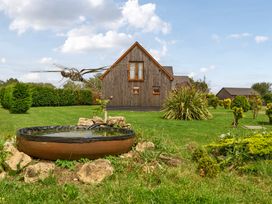 A garden with a house and water basin at Charcoal Lodge in Brigg