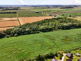 An aerial view of fields with trees and a river at Charcoal Lodge in Brigg