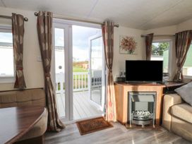A living room with a television and fireplace at 46 Foxburrow Hang in Great Yarmouth