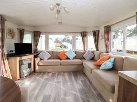 A living room with a sofa and television at 46 Foxburrow Hang in Great Yarmouth