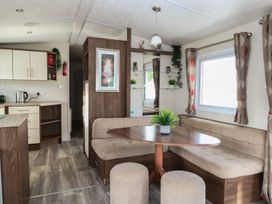 A living room with a dining table and kitchen in 46 Foxburrow Hang Great Yarmouth