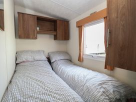 A bedroom with two beds and a shelf at 46 Foxburrow Hang in Great Yarmouth