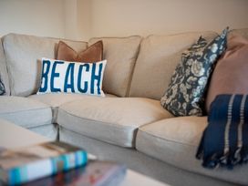 A living room with a sofa and decorative pillows at The Old Boat House in Lyme Regis
