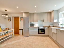 A kitchen with refrigerator, oven, and table at The Old Boat House in Lyme Regis