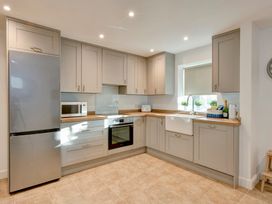 A kitchen with a refrigerator, microwave, oven, and sink at The Old Boat House in Lyme Regis