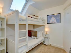 A bedroom with a bunk bed and a lamp at The Old Boat House in Lyme Regis