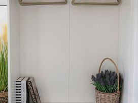 A closet with clothes hangers and a basket of lavender at The Old Boat House Lyme Regis