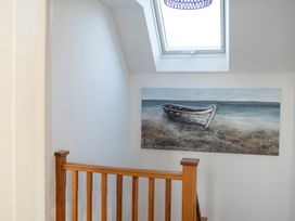 A staircase with a handrail and a painting of a boat at The Old Boat House Lyme Regis