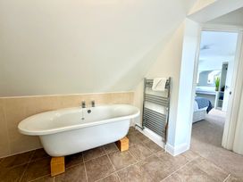 A bathroom with a bathtub and towel rail at The Old Boat House in Lyme Regis