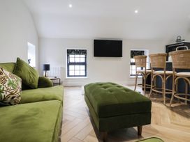 A living room with a green sofa and television at The Old Bakehouse in 