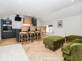 A kitchen with bar stools and appliances at The Old Bakehouse in 