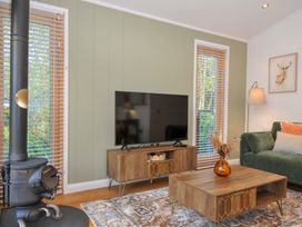 A living room with a wood stove and television at 6 Stonerush Valley in Looe
