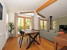 A living room with a dining table and windows at 6 Stonerush Valley Looe