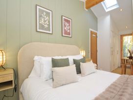 A bedroom with a bed and artwork on the walls at 6 Stonerush Valley, Looe