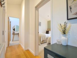 A hallway with a table and doors leading to rooms at 6 Stonerush Valley in Looe